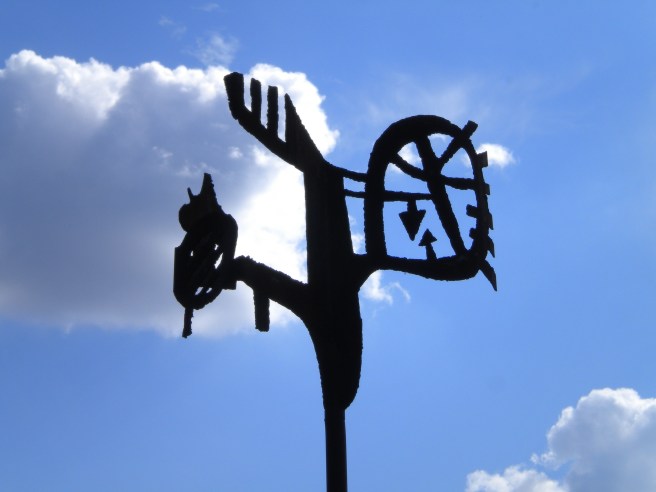 Schwarze Skulptur vor strahlend blauem Himmel
